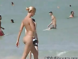 Topless skinny babe with cute tits runs away from the beach.
