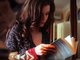 Romantic dark haired babe is getting aroused while reading a book